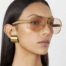 Load image into Gallery viewer, Woman wearing gold aviator sunglasses with a plain background